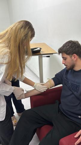 katılımcılardan biri diğerinden kan alırken